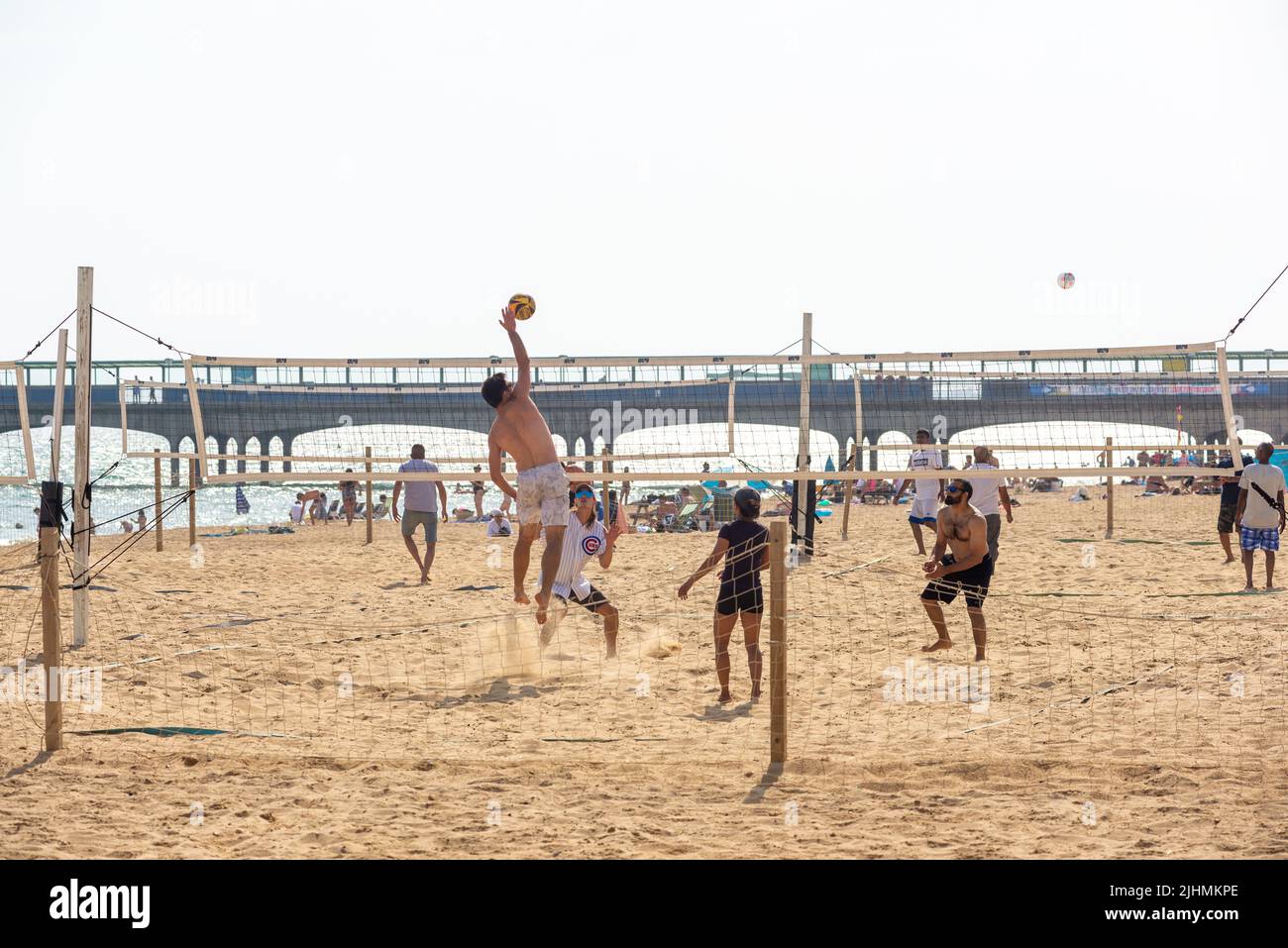 Boscombe Beach, Bournemouth, Dorset, Inglaterra, Reino Unido, 19th Julio 2022, Tiempo. Sol caliente a última hora de la tarde en la costa sur mientras la ola de calor récord empieza a moderarse. Los amigos juegan al voleibol en la playa. Crédito: Paul Biggins/Alamy Live News Foto de stock