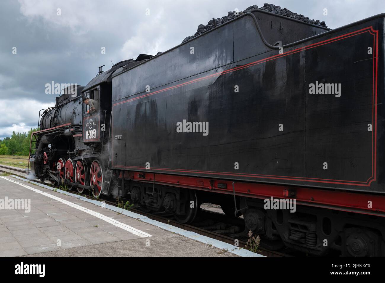 KUZHENKINO, RUSIA - 16 DE JULIO de 2022: La antigua locomotora de vapor soviética L-3051 se acerca en un día nublado de julio. Estación Kuzhenkino. Región de Tver Foto de stock