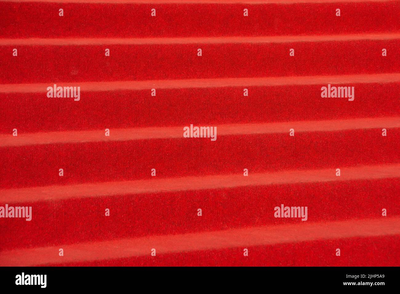 Alfombra roja en las escaleras en un interior de lujo, vista de cerca Foto de stock