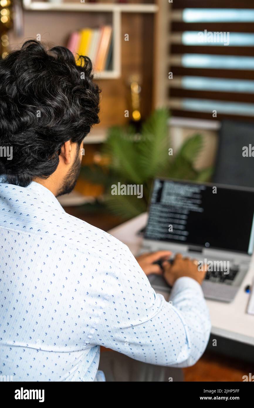 Imagen vertical del hombro de la codificación de los empleados DE TI en el portátil de la oficina, conepta de los desarrolladores de software, mientras trabajan en el collar y los expertos Foto de stock