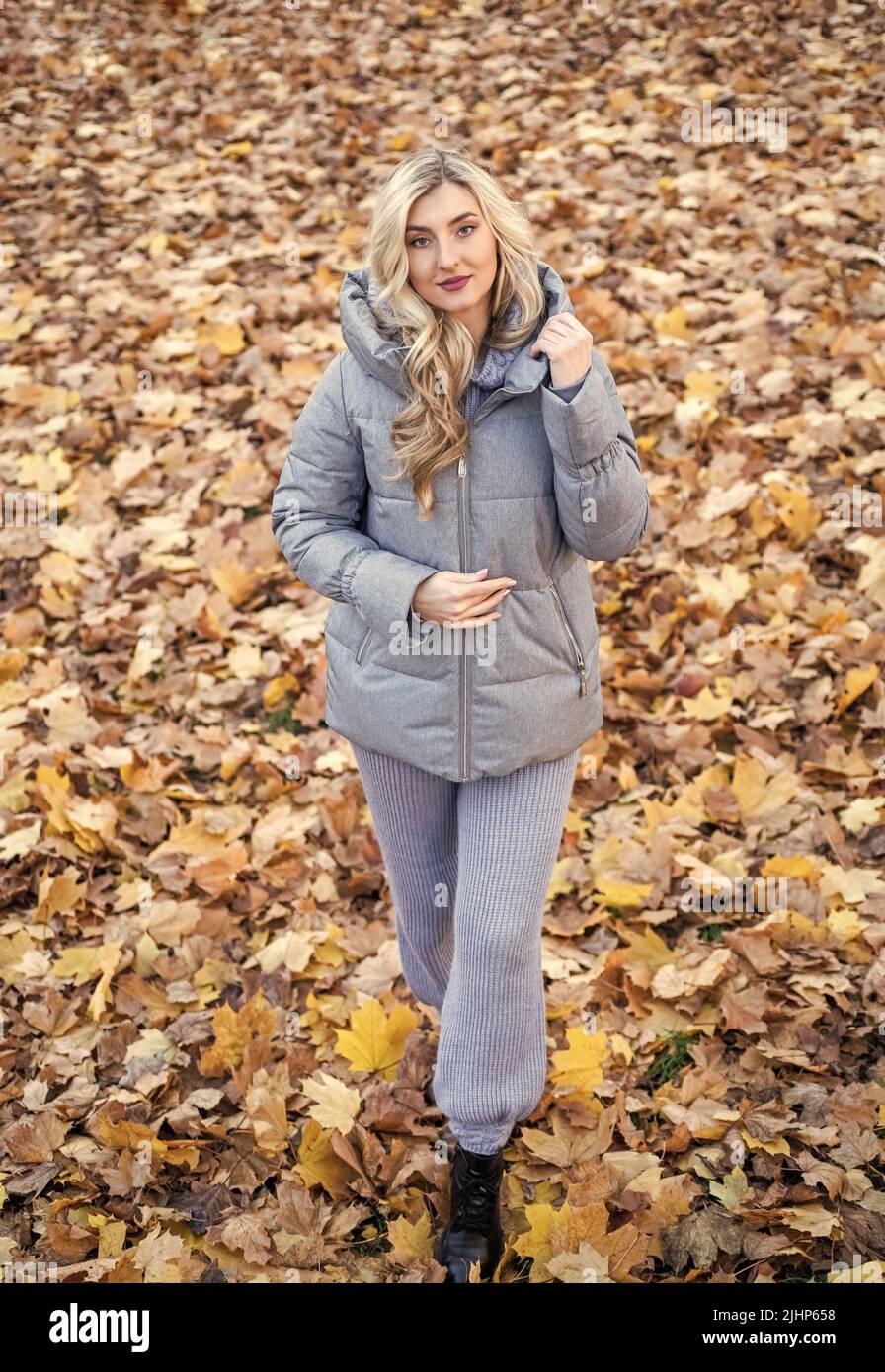mujer bonita con pelo largo rubio rizado vestir otoño puffer abrigo en el  bosque con hojas caídas, de moda Fotografía de stock - Alamy