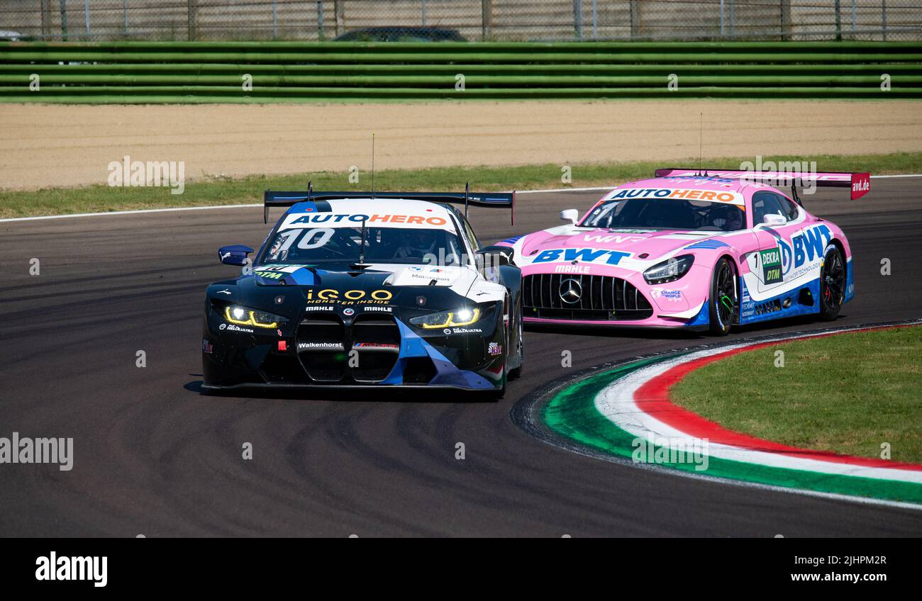 BMW M4 y Mercedes AMG desafiantes súper carrera de coches de acción rápido en pista de asfalto. Imola, Italia, junio de 18 2022. DTM Foto de stock