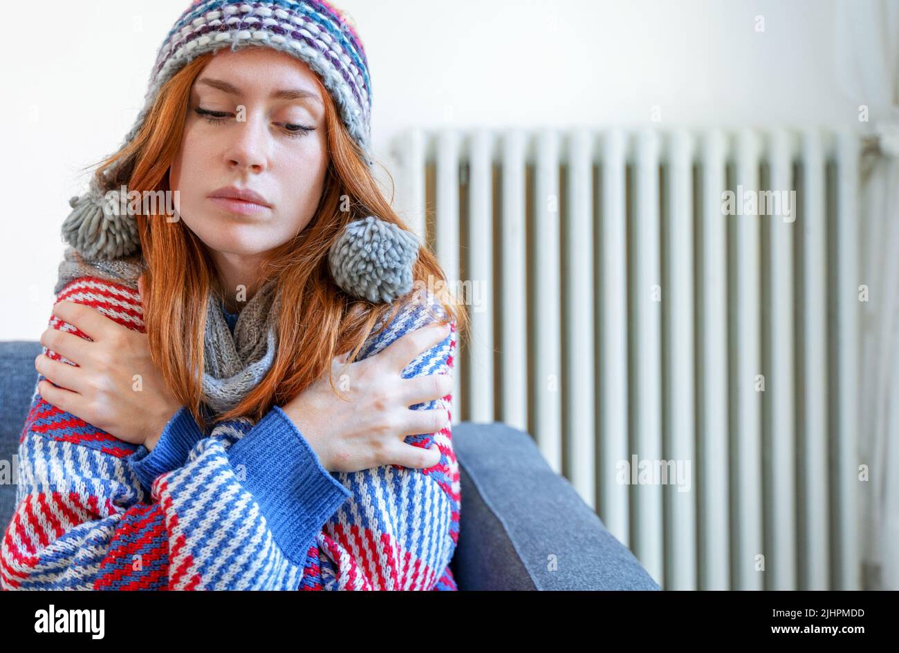 Una persona que se siente fría en casa tiene un problema de calefacción Foto de stock
