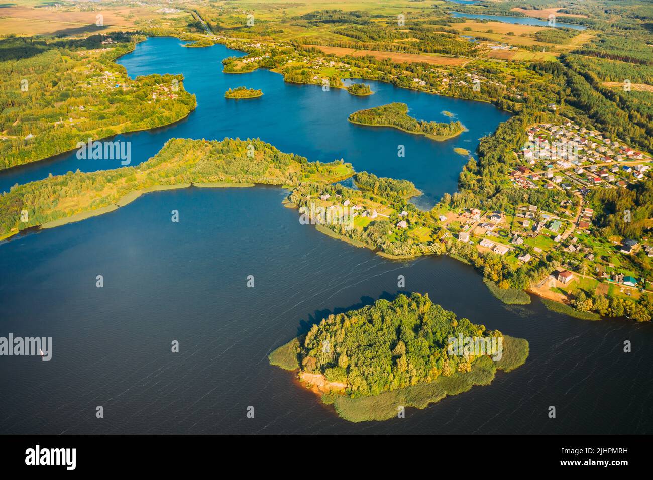 Distrito de Lyepyel, Lago Lepel, Distrito de Beloozerny, Región de Vitebsk. Vista aérea de la zona residencial con casas en el campo. Vista superior de la isla desde Foto de stock