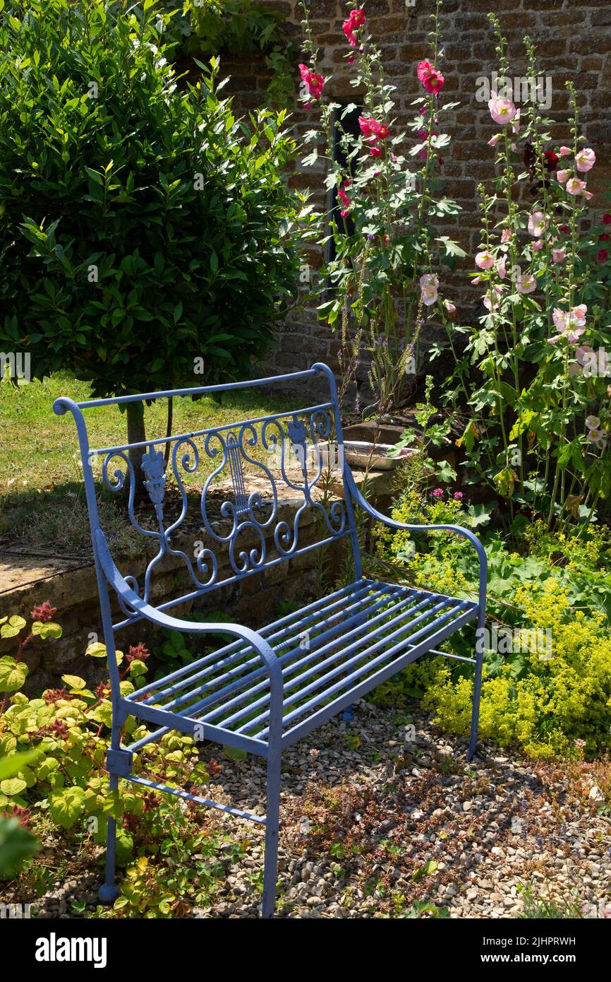 Banco de jardín de metal en jardín inglés, Inglaterra Foto de stock