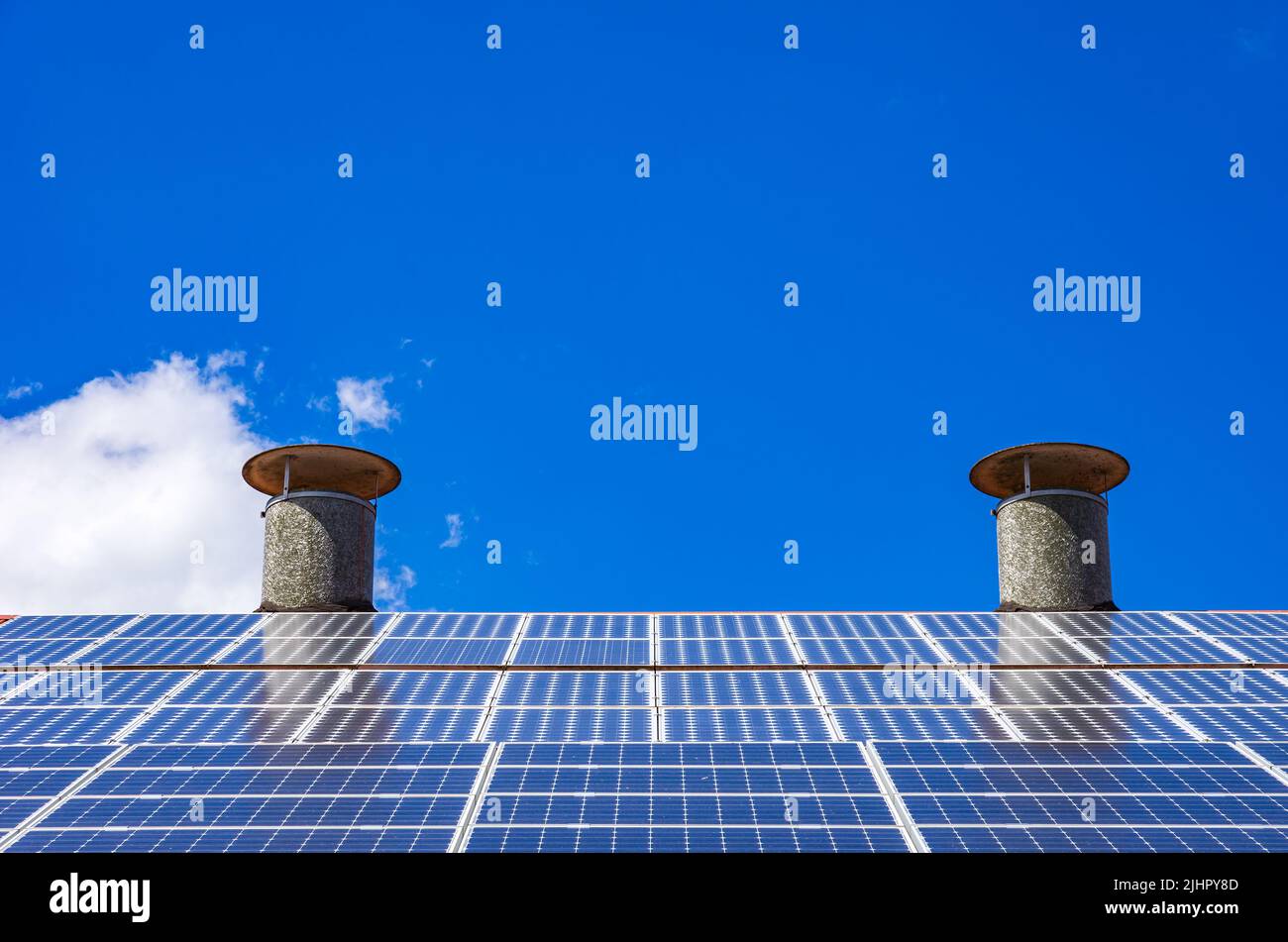 Sistema fotovoltaico doméstico o pequeña planta de energía solar en el techo de una casa. Foto de stock
