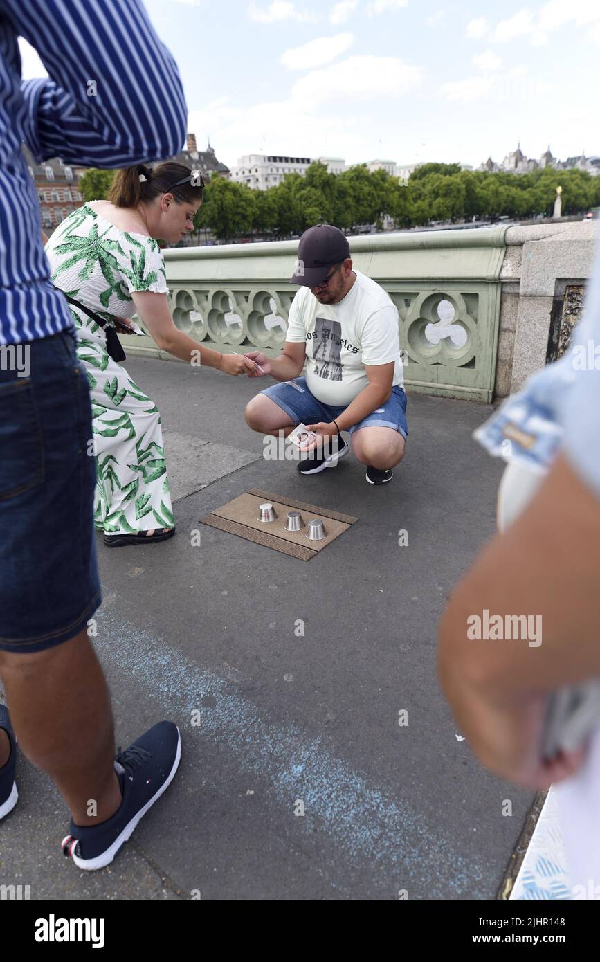 El juego de conchas / tres tazas Trick - estafa ilegal en el puente de Westminster, Londres, Inglaterra, Reino Unido. Foto de stock