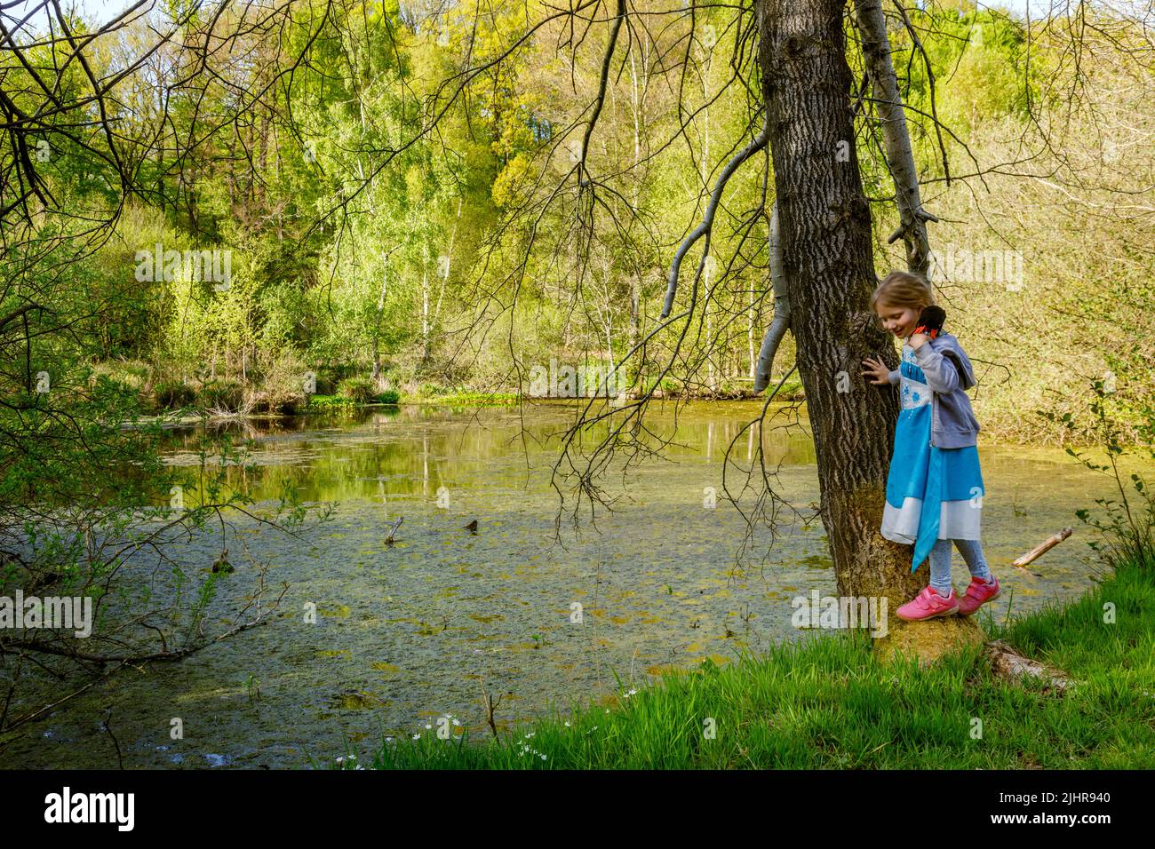 Kleines Mädchen spielt am Ufer eines Teiches, Gieselautal in Süderdithmarschen am Steinzeitpark Albersdorf Foto de stock