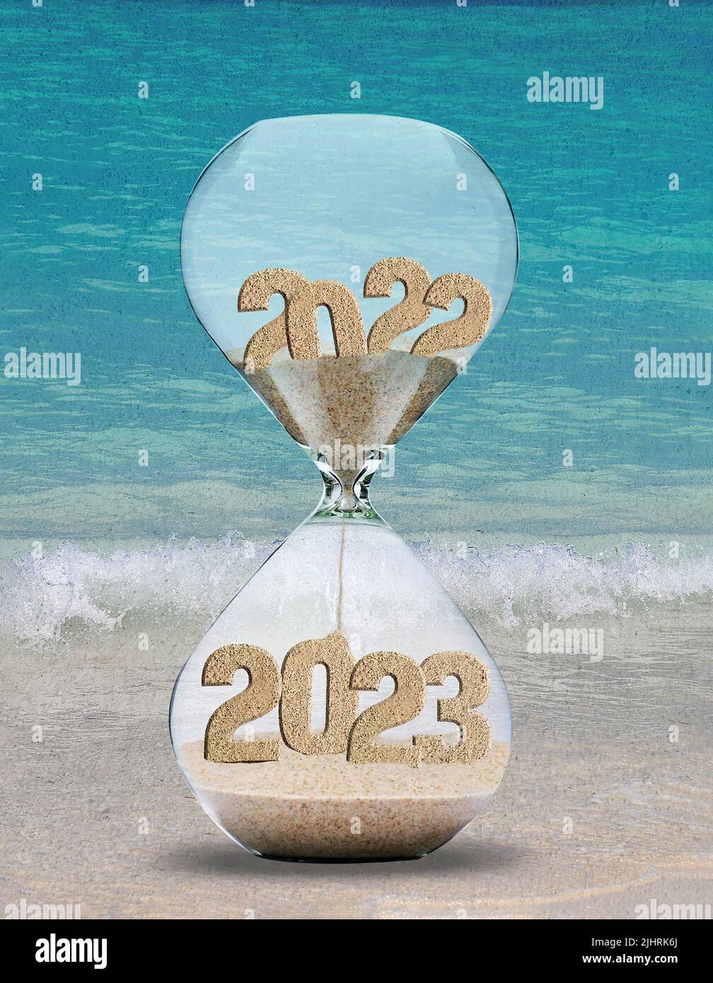 Temporizador de arena de Año Nuevo 2023 en la arena de la playa con un fondo de acuarela turquesa del océano Foto de stock