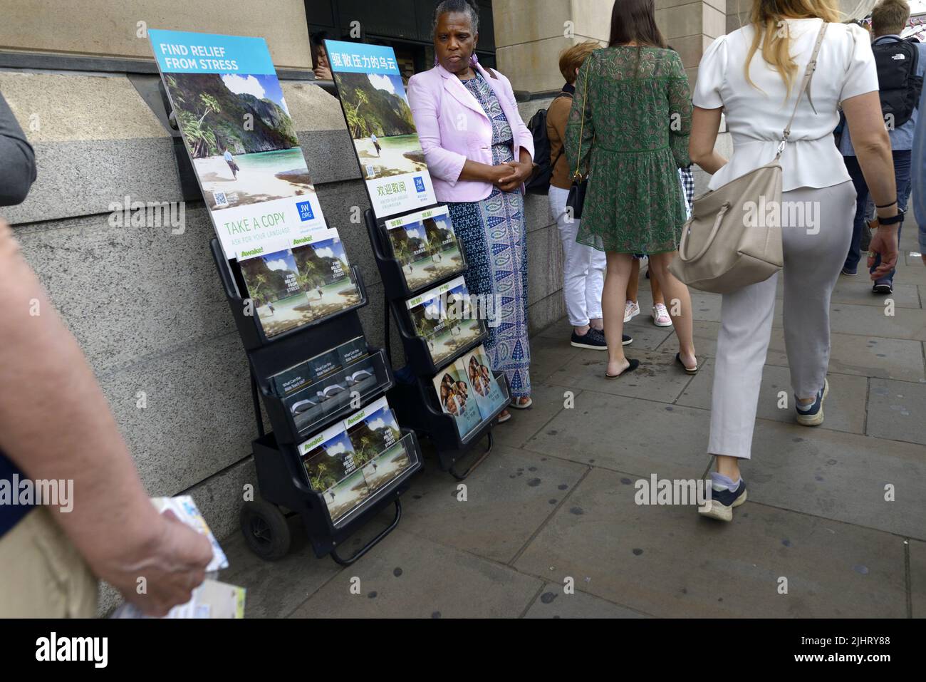 Londres, Inglaterra, Reino Unido. Miembro de los Testigos de Jova regalando copias de '¡Despierta!' Fuera de la estación de metro Westminster Foto de stock