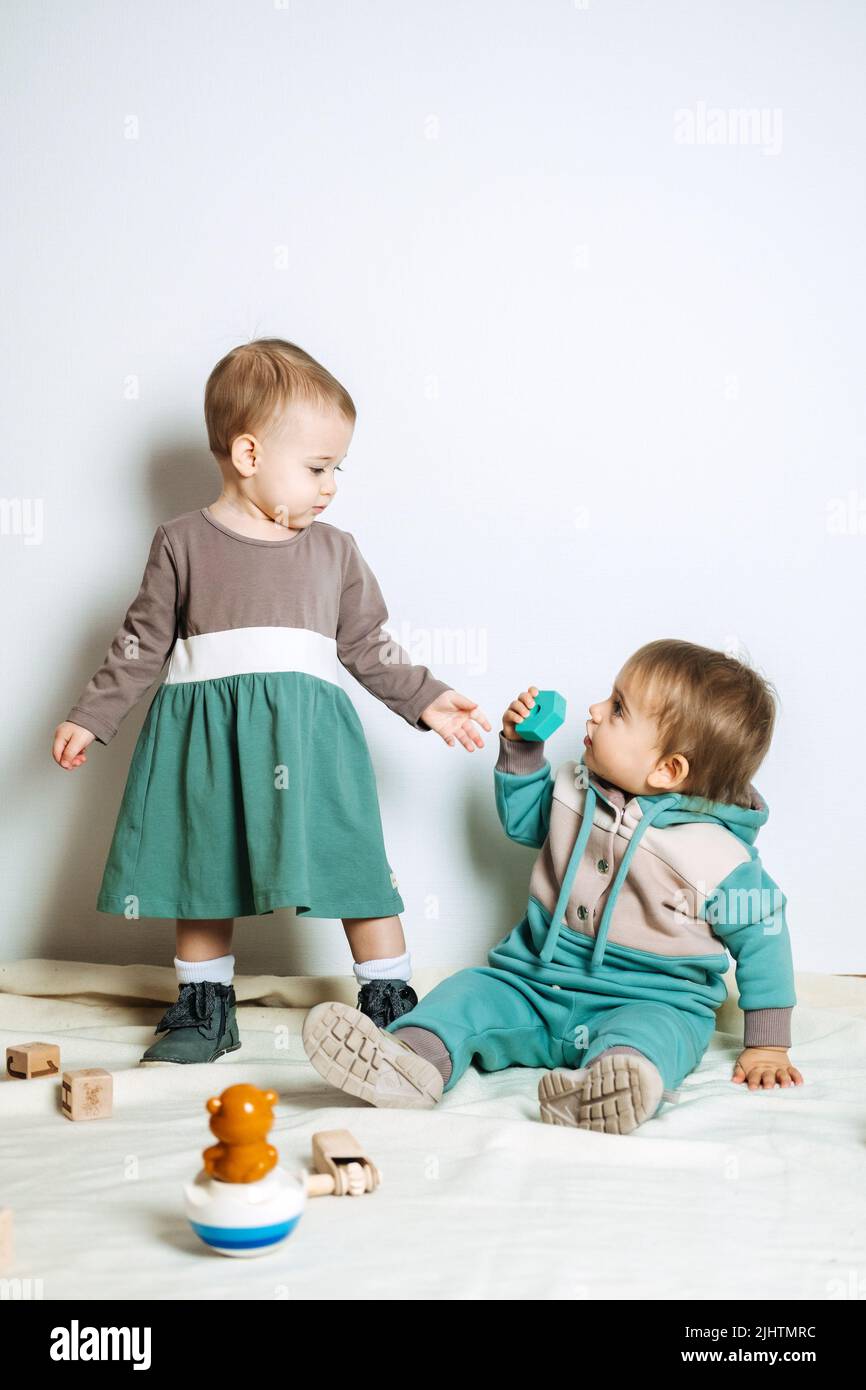 Indica Maletín barco Moda para bebés. Ropa unisex neutra para bebés. Dos muchachas bonitas en  tela de algodón de paleta de colores neutros Fotografía de stock - Alamy