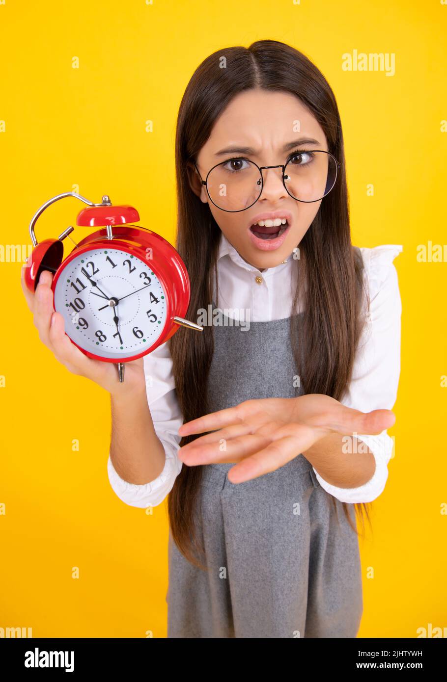 Niña adolescente de 12, 13, 14 años de edad Mira el reloj despertador. Es  hora de comprar ventas. Buenos días, comprobando la hora. Cara enojada,  emociones disgustadas de niña adolescente Fotografía de stock - Alamy