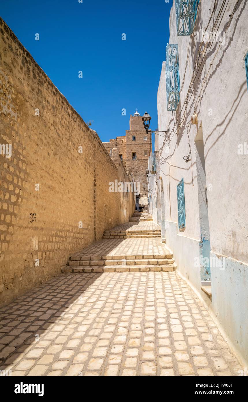Un carril sube por una colina al lado de la antigua muralla de la ciudad de Sousse Medina hacia el faro de Sousse Kasbah, Túnez Foto de stock