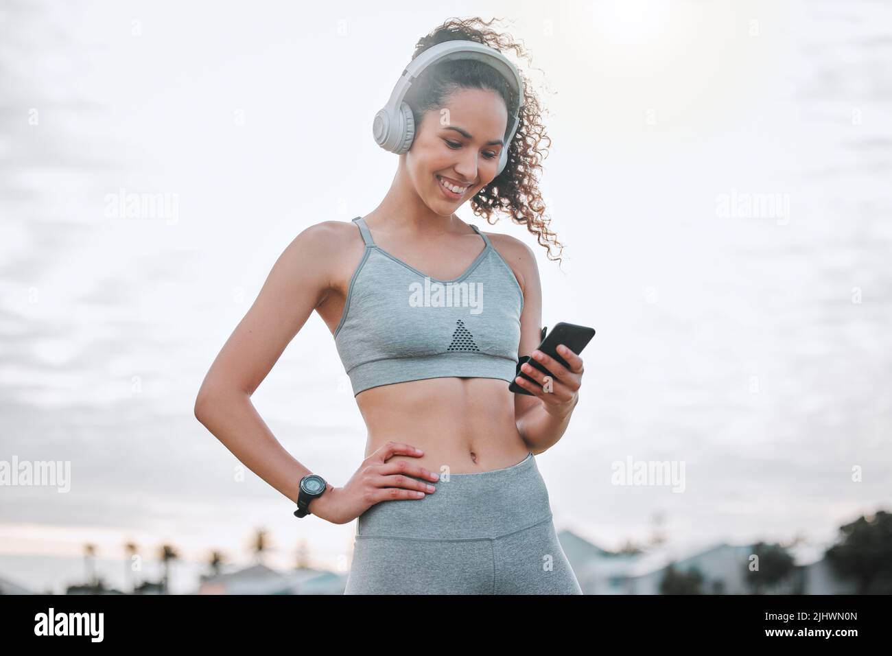 Seguimiento de su progreso personal. Una atractiva atleta joven que hace ejercicio al aire libre. Foto de stock