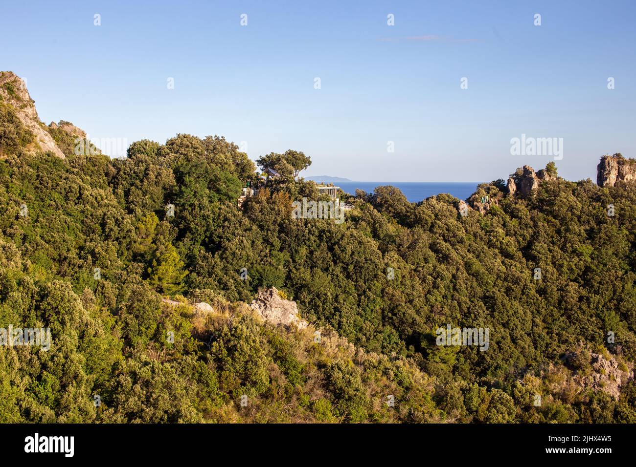 Villa de lujo escondida en la costa de Amalfi en un paisaje mediterráneo con árboles y rocas Foto de stock