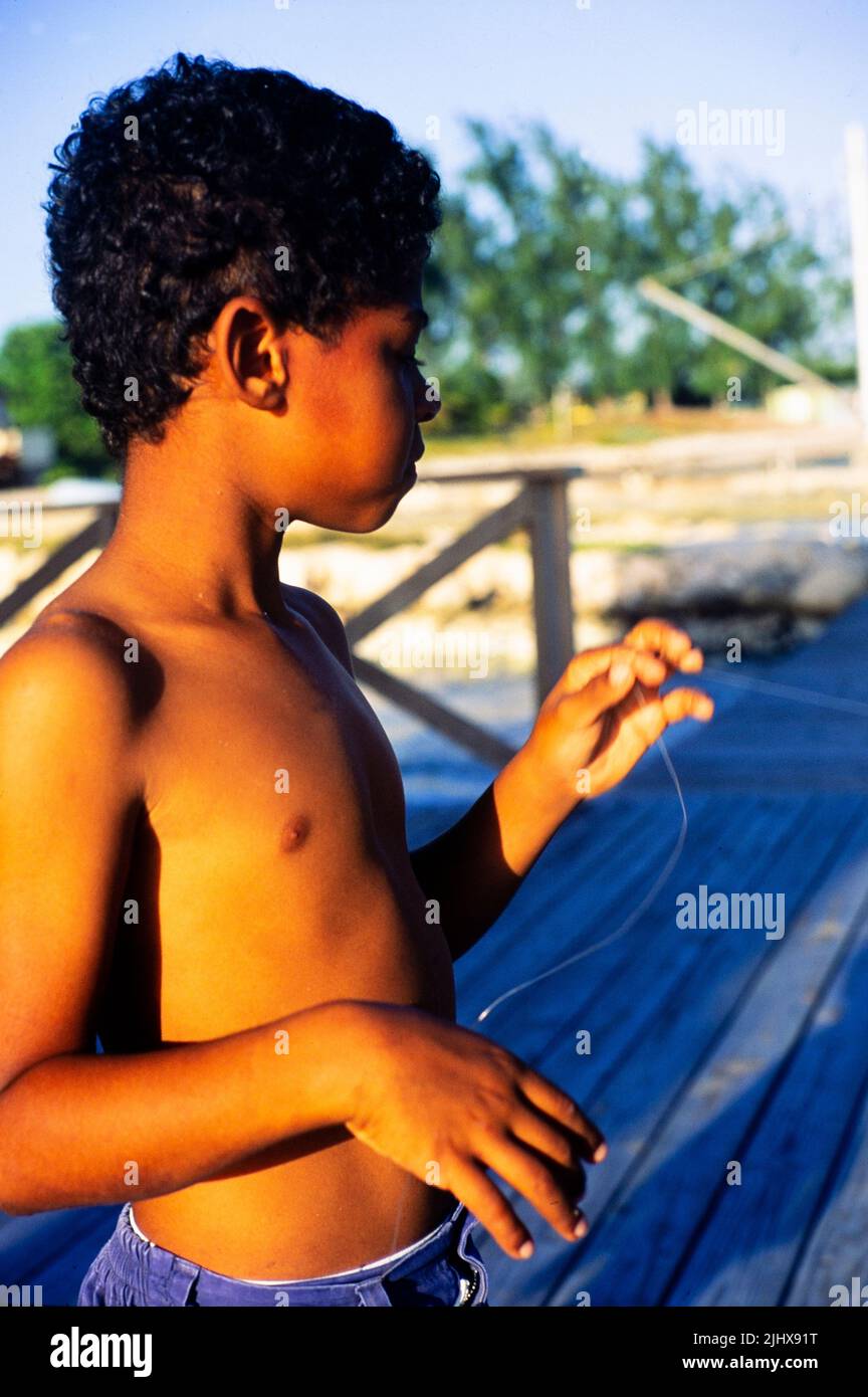 Joven que concentra la línea de pesca, Caimán Brac, Islas Caimán, Indias Occidentales c 1990 Foto de stock