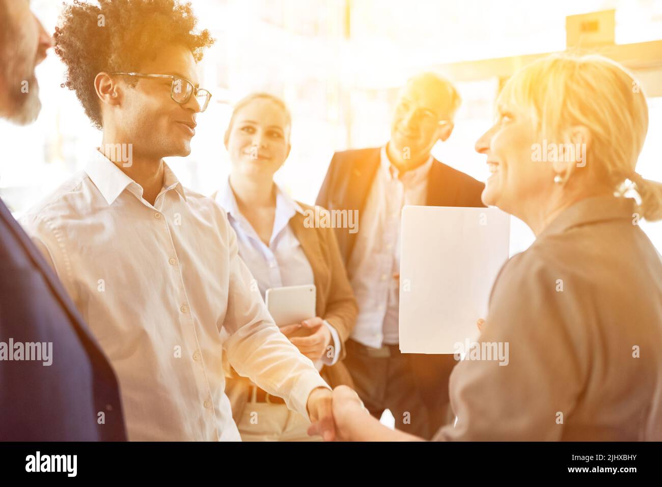 Los empresarios de éxito se dan la mano mientras trabajan juntos en la oficina Foto de stock