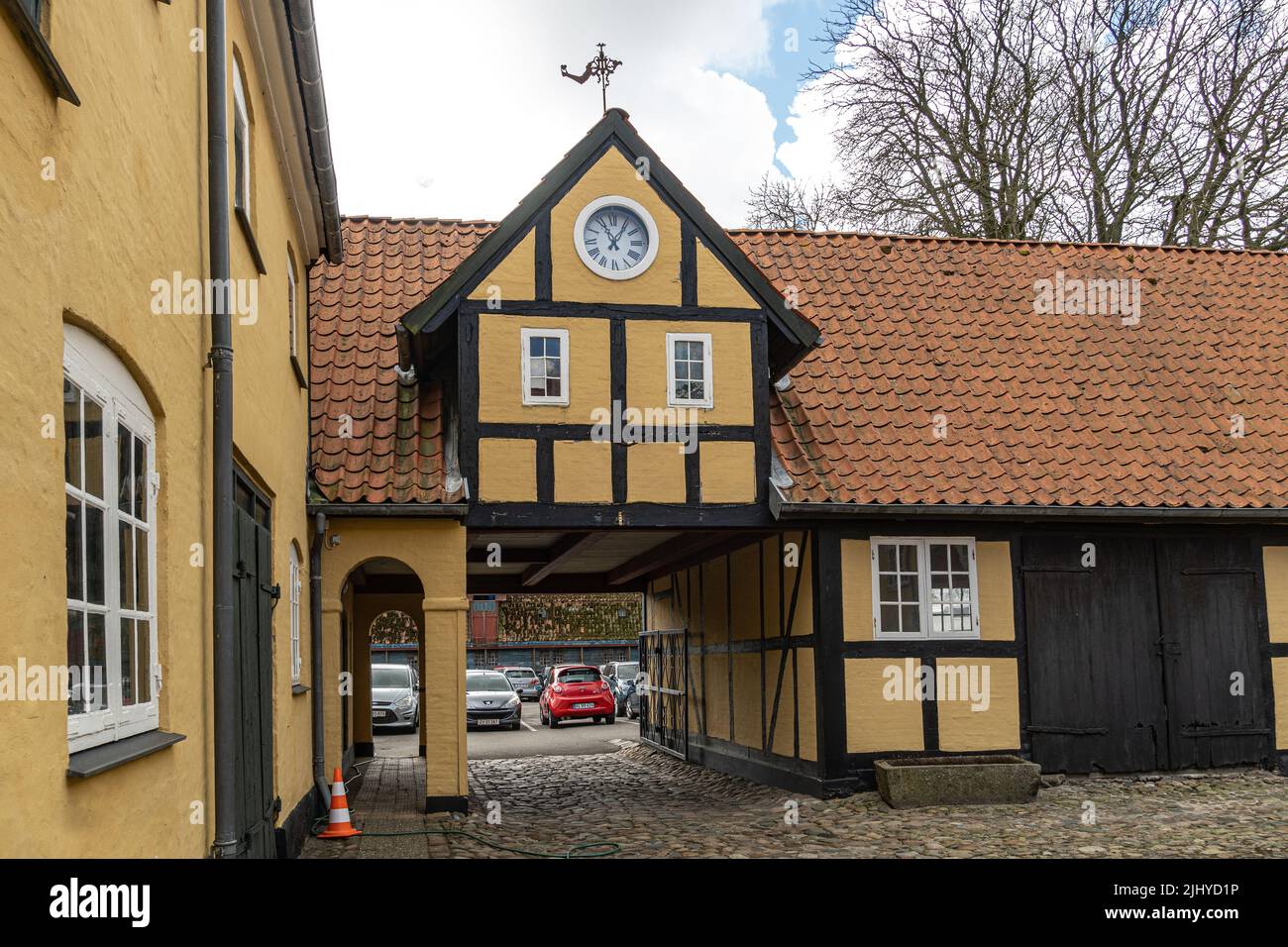 Detalle arquitectónico de un edificio danés tradicional con el reloj y la veleta. Assens, Dinamarca, Europa Foto de stock