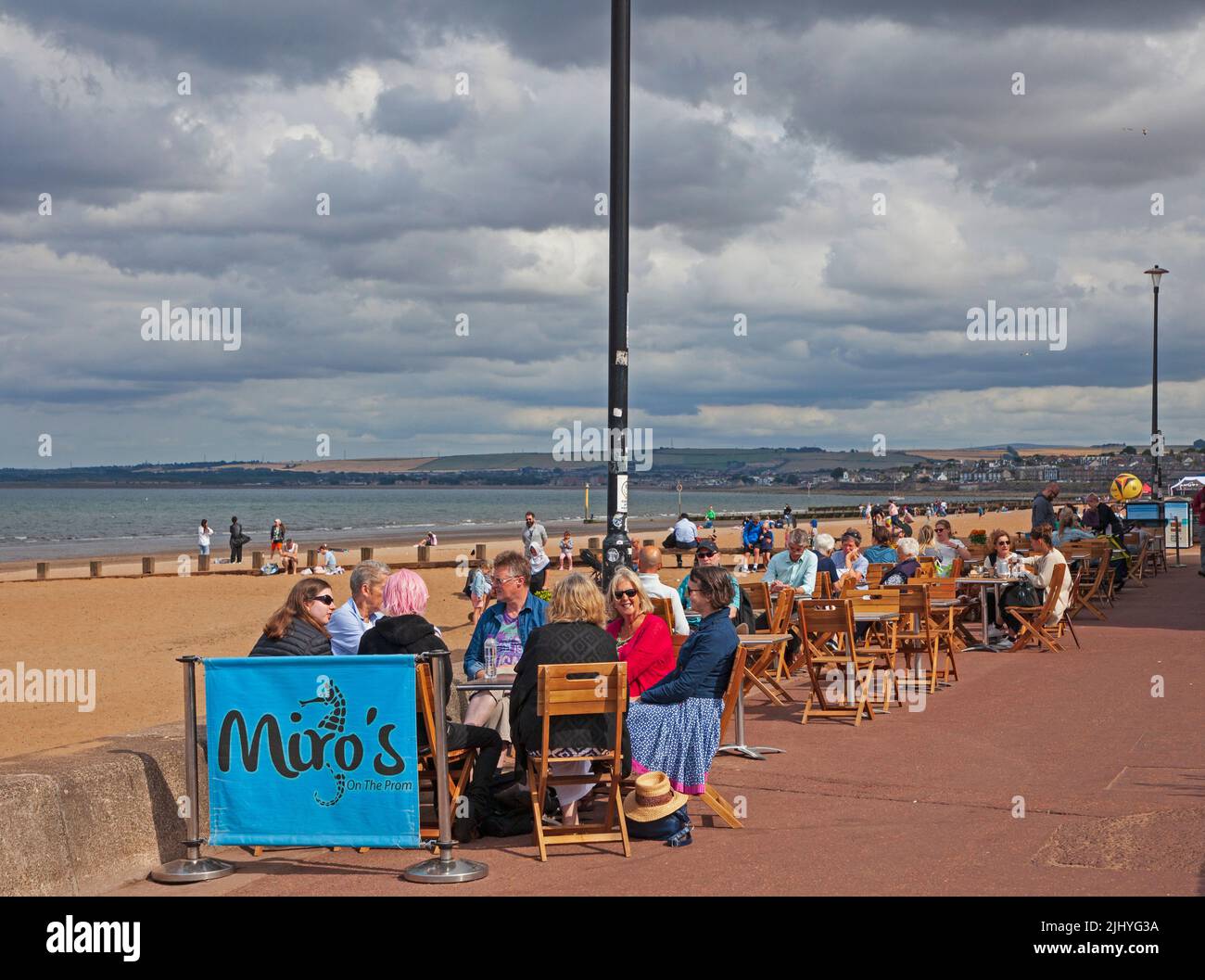 Portobello, Edimburgo, Escocia, Reino Unido. 21st de julio de 2022. Ventoso y nublado con ocasionales períodos de sol en la costa con una temperatura de 18 grados con un viento frío de 18 km/h y posibles ráfagas de 37 km/h para los pocos que lo visitaron para sentarse en la playa de arena o comer y beber en los cafés del paseo marítimo. Crédito: Scottishcreative/alamy live news. Foto de stock
