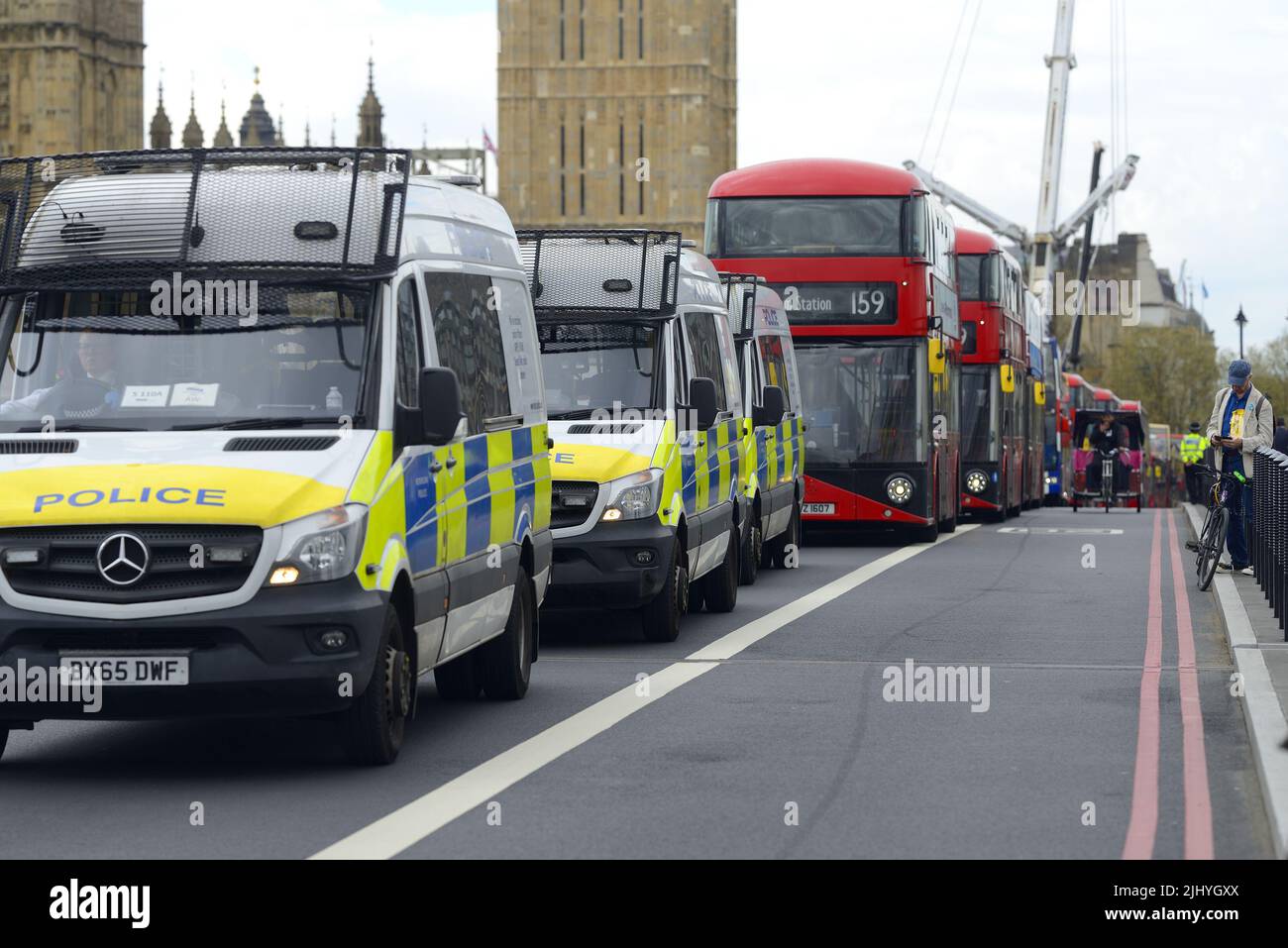Londres, Inglaterra, Reino Unido. Furgonetas de policía y autobuses rojos de dos pisos en el puente de Westminster como una manifestación detiene el tráfico Foto de stock