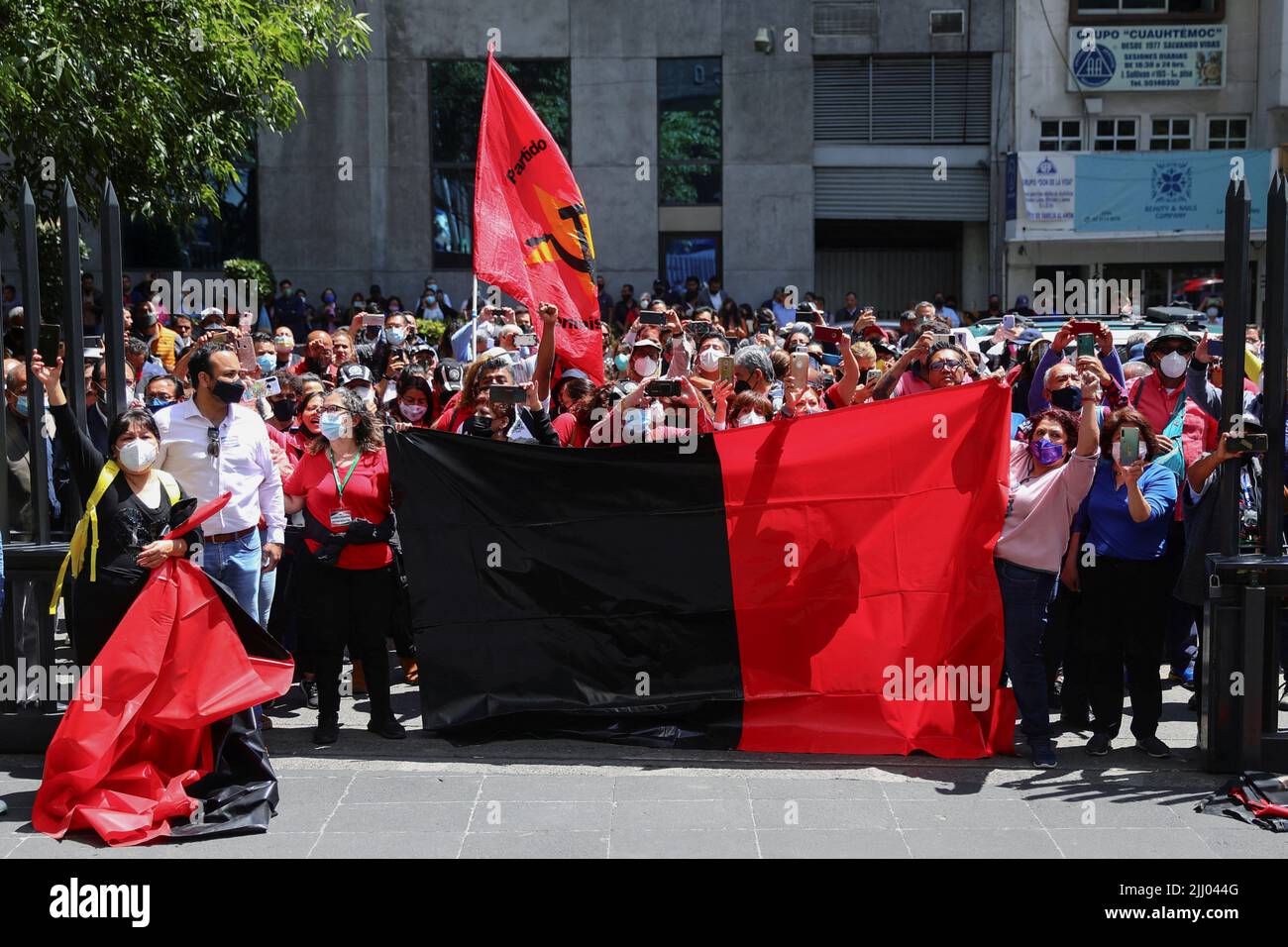 Los empleados tienen una bandera mientras protestan fuera de la sede de Telmex después de que el sindicato de la compañía se declarara en huelga después de no llegar a un acuerdo con la compañía sobre un nuevo convenio colectivo, en Ciudad de México, México, el 21 de julio de 2022. REUTERS/Edgard Garrido Foto de stock