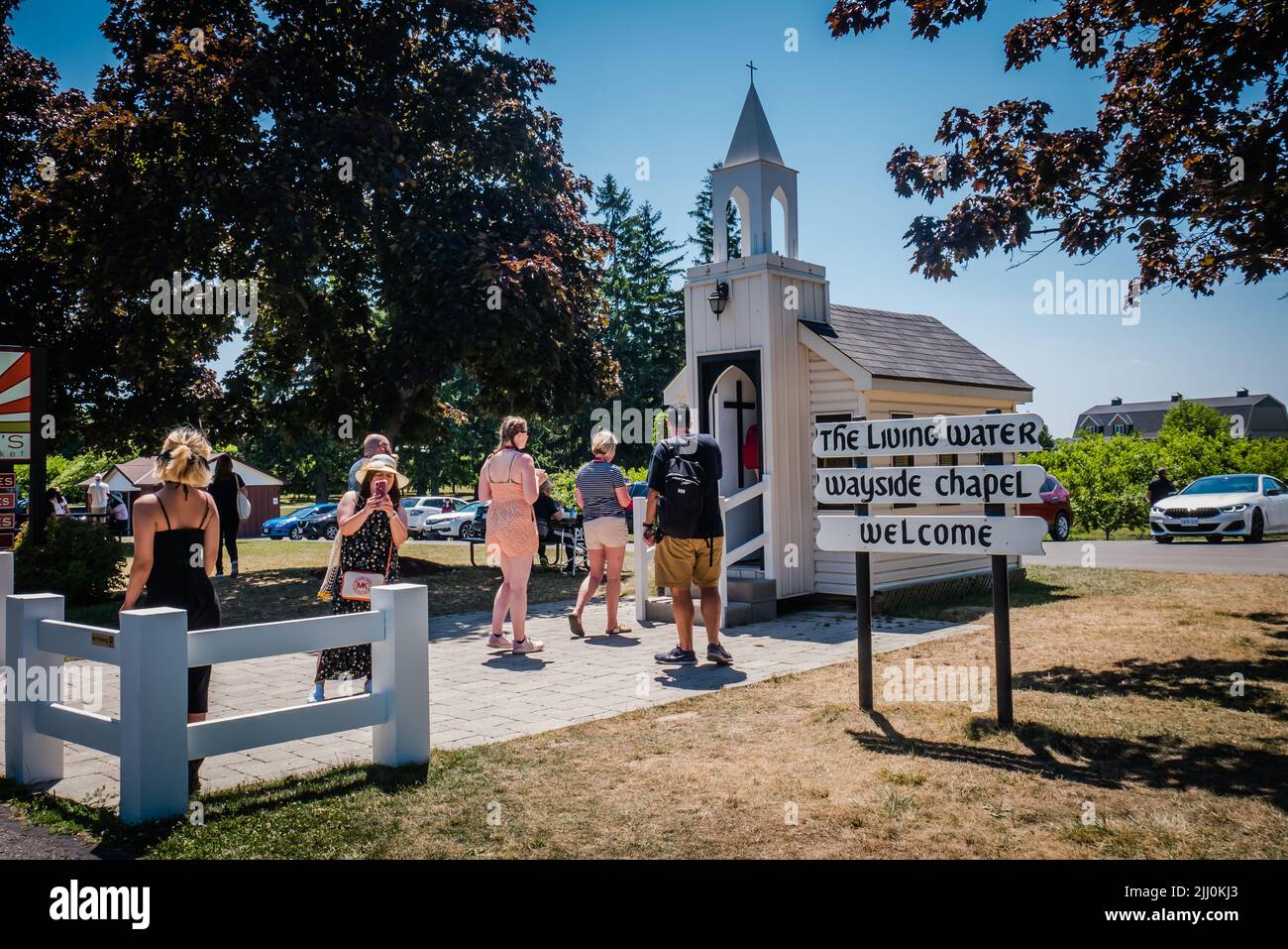 Los turistas que visitan la iglesia más pequeña de canadá, agua viva capilla al borde del camino Foto de stock