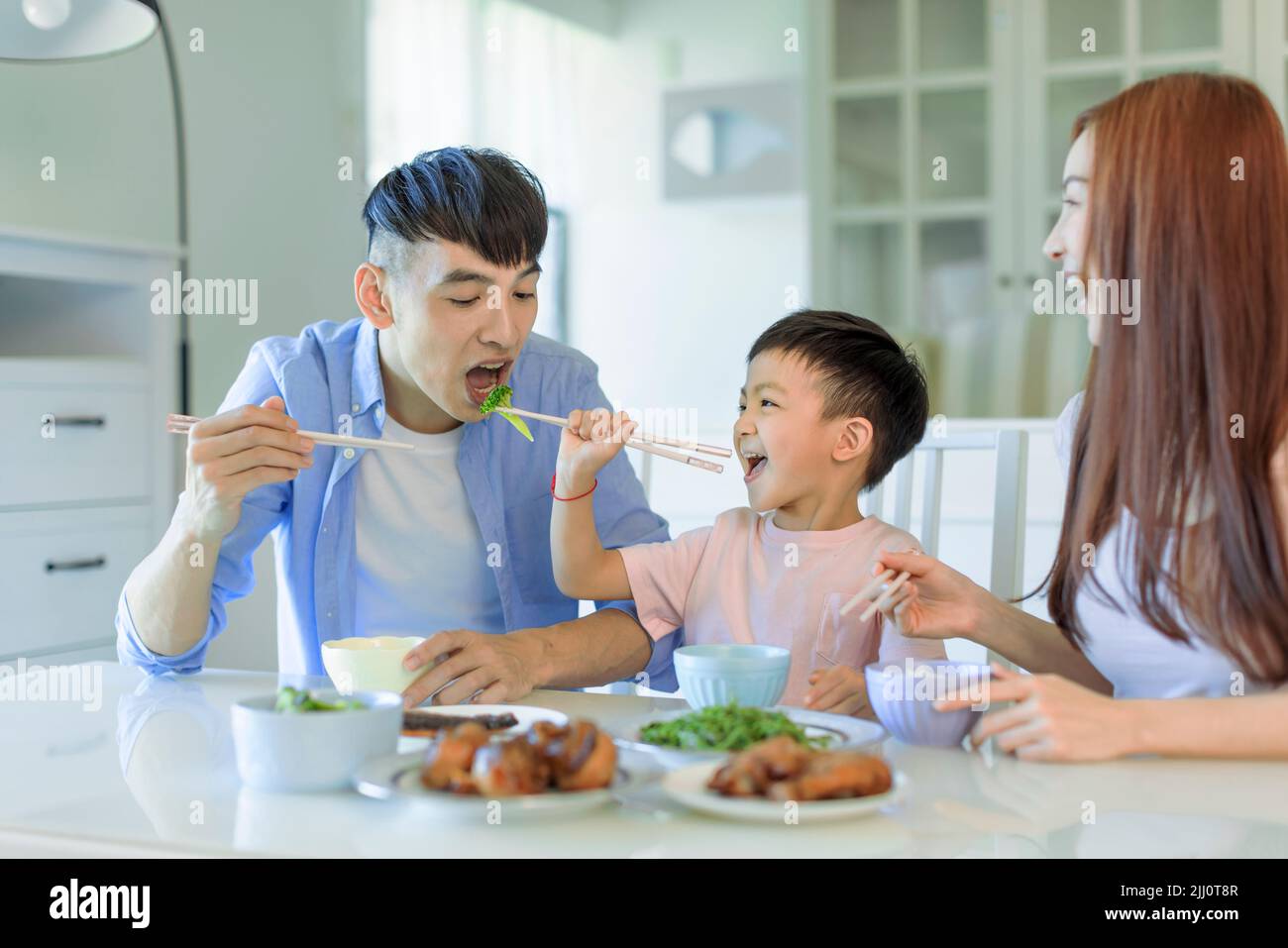Feliz familia asiática cenando en casa Foto de stock