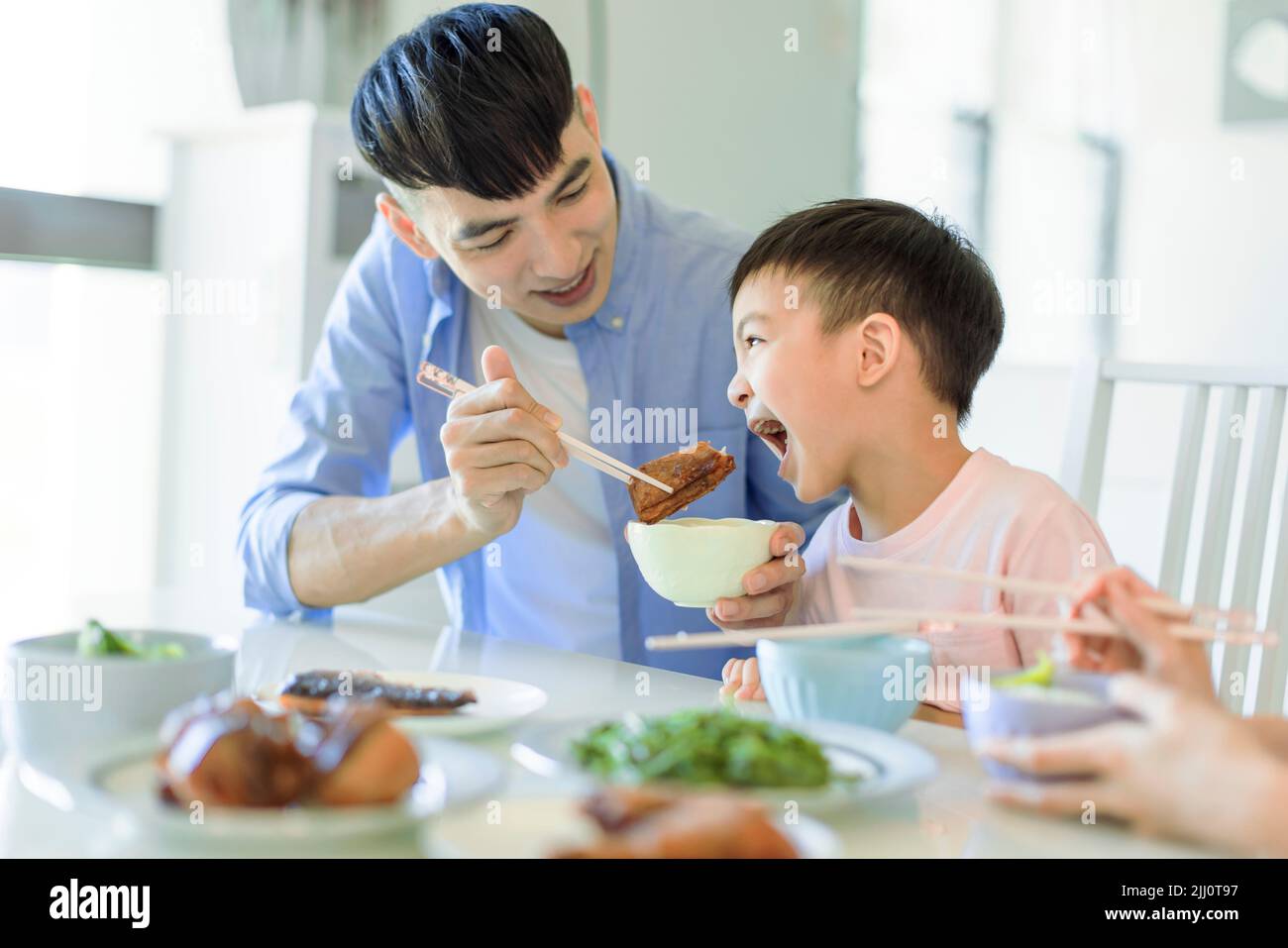 Feliz padre e hijo cenando en casa Foto de stock