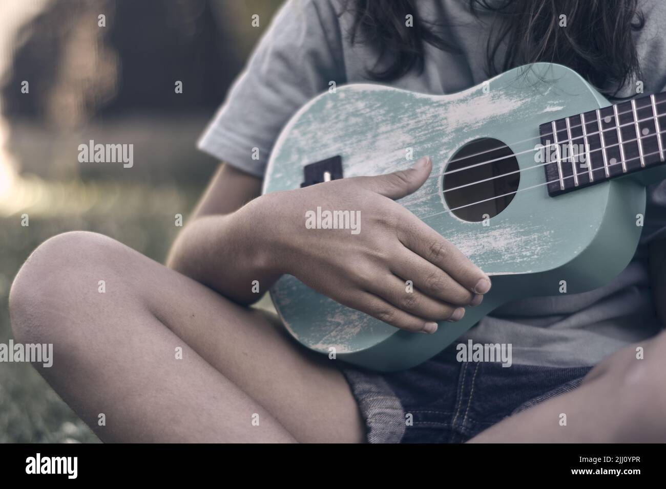 Primer plano de una mano jugando un ukelele azul turquesa Fotografía de  stock - Alamy