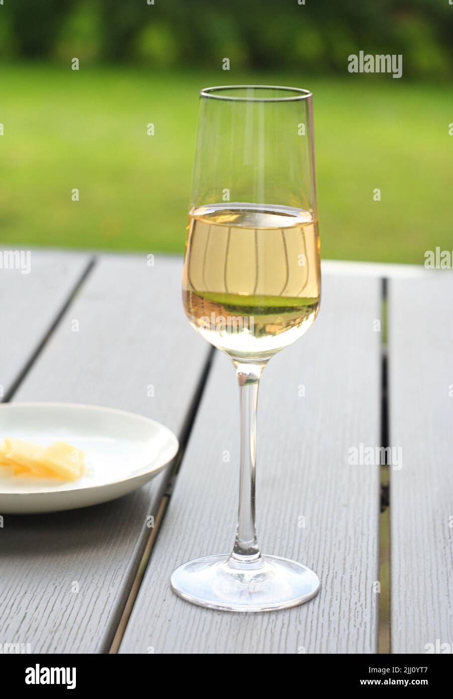 Una copa de vino blanco seco está sobre la mesa. Es un día de verano Foto de stock