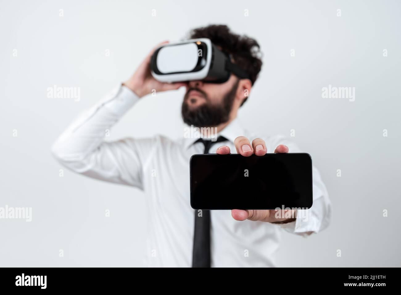 Standig Hombre sosteniendo teléfono móvil con mensajes importantes y usando gafas  VR. Hombre de negocios con gafas de Realidad Virtual y pantalla de teléfono  celular Fotografía de stock - Alamy