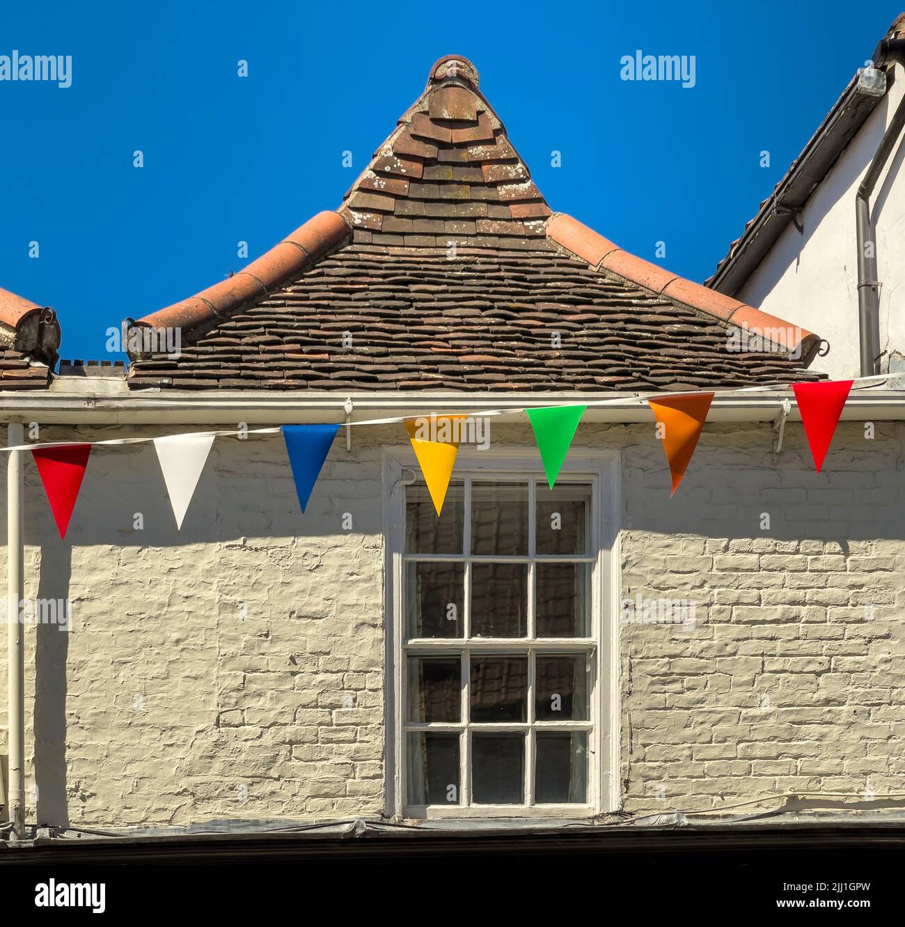 Antiguo tejado de azulejos en el centro de York con banderitas de colores, Reino Unido Foto de stock