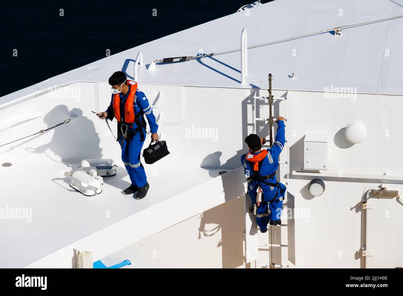 El personal de mantenimiento de los buques se prepara para trabajar con EPI completo en el MS Iona, atracado en Stavanger, Noruega Foto de stock