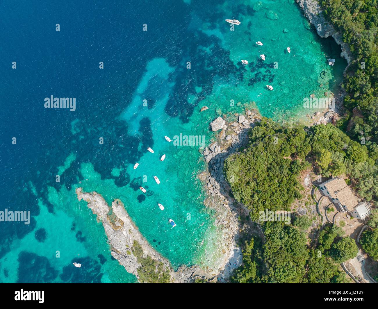 Vista aérea de la playa de Klimatia, cerca de la playa de Limni en la isla de Corfú. Línea costera. Aguas transparentes y cristalinas, barcos amarrados. Grecia Foto de stock