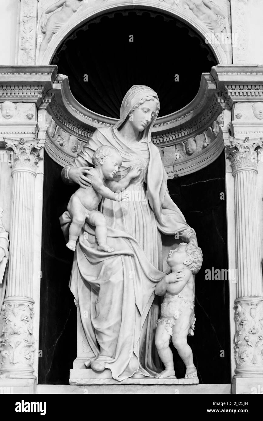 Foto en blanco y negro de la escultura de mármol de una mujer con dos niños dentro del templo romano en Nápoles, Italia Foto de stock