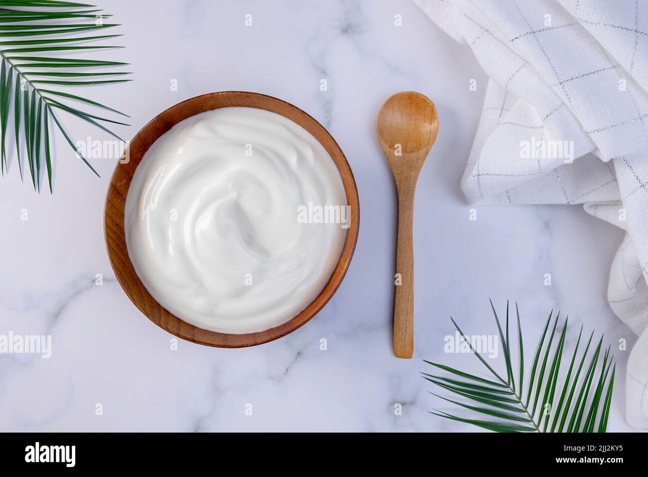 Una porción de yogur griego en un tazón de madera listo para ser servido. Alimentos saludables para el concepto de dieta. Foto de stock