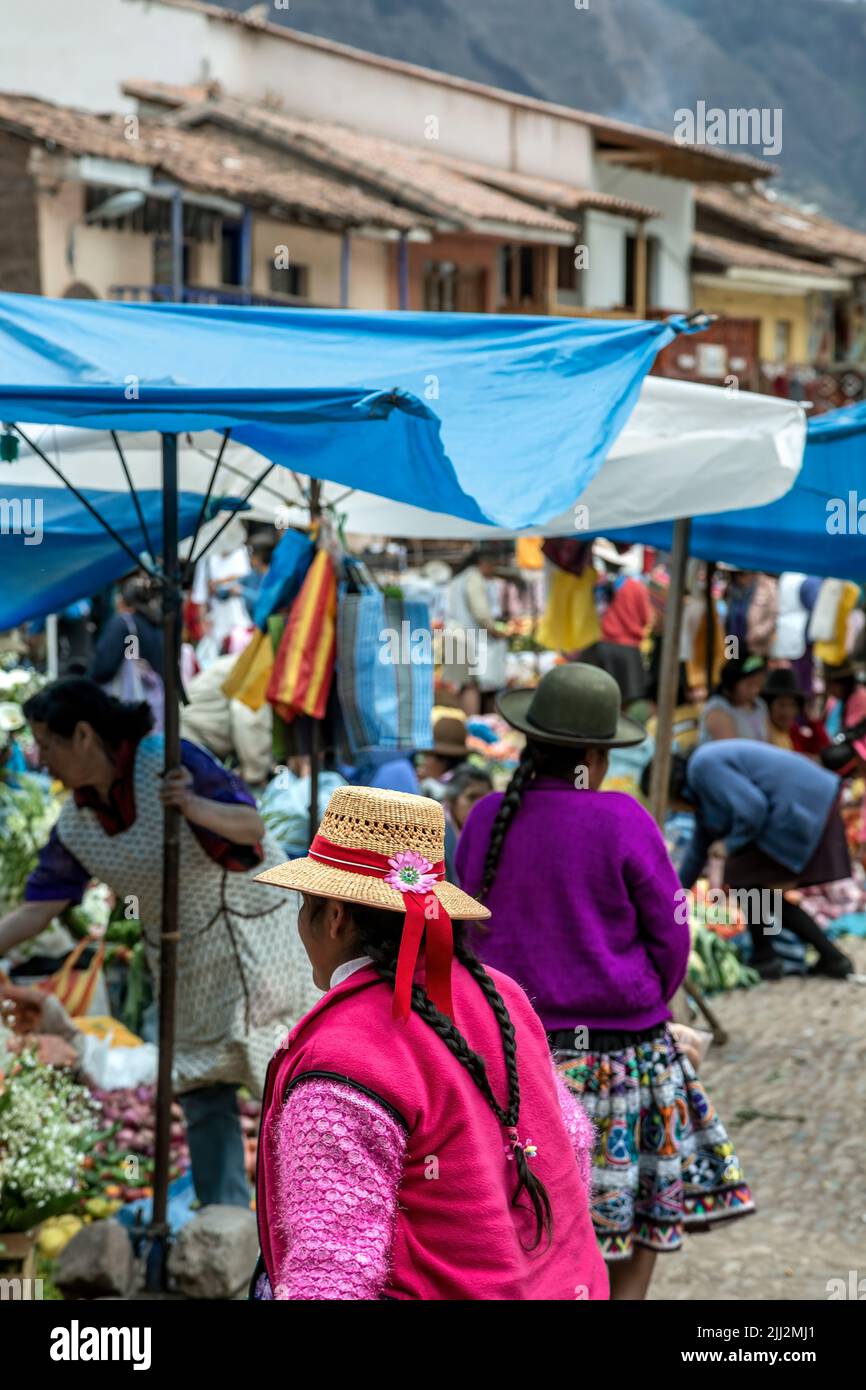 Mujeres quechuas y puestos de productos, Mercado Dominical de Pisac, Cusco, Perú Foto de stock