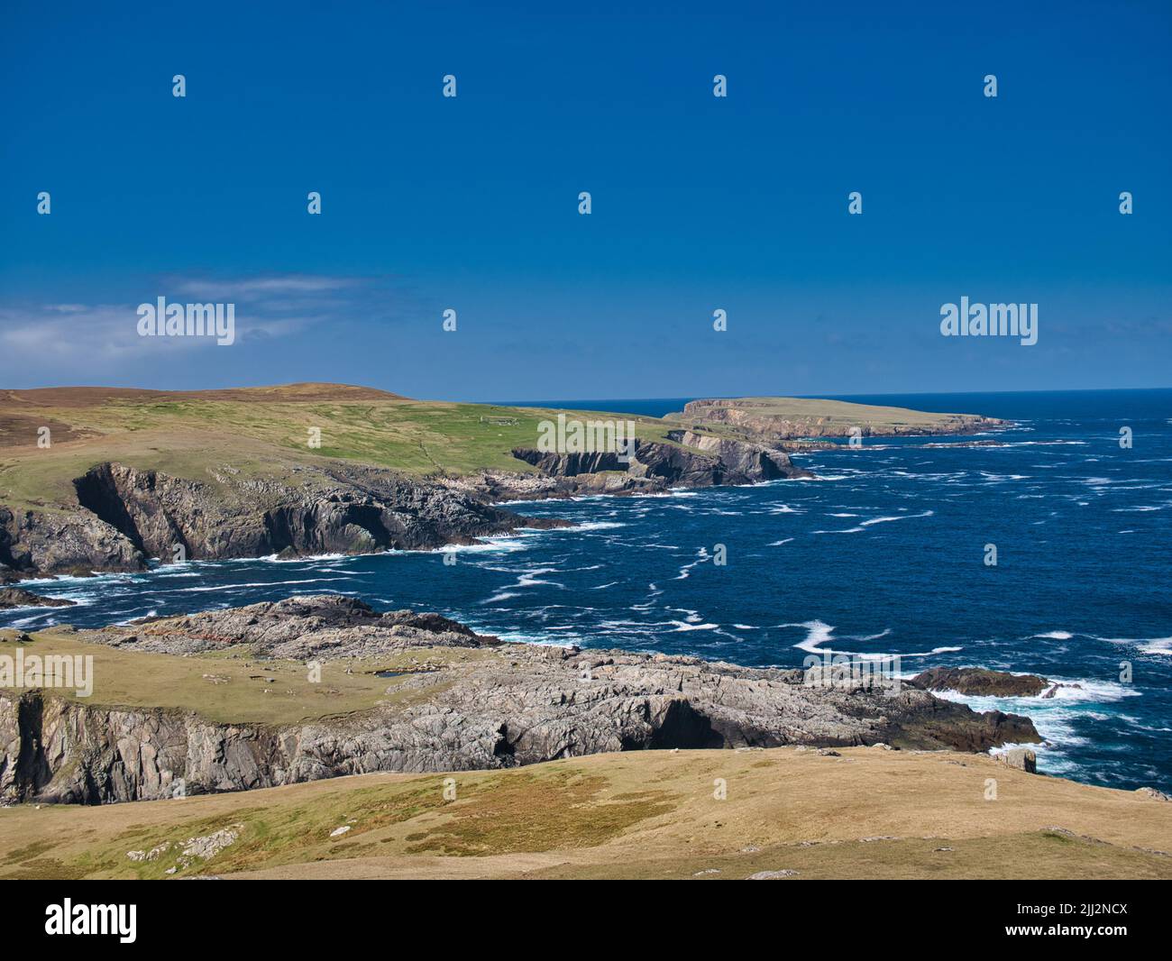 El escarpado paisaje de acantilados costeros y las prístinas aguas de color turquesa alrededor de la isla de Uyea en Northmavine, Shetland, Reino Unido. Foto de stock