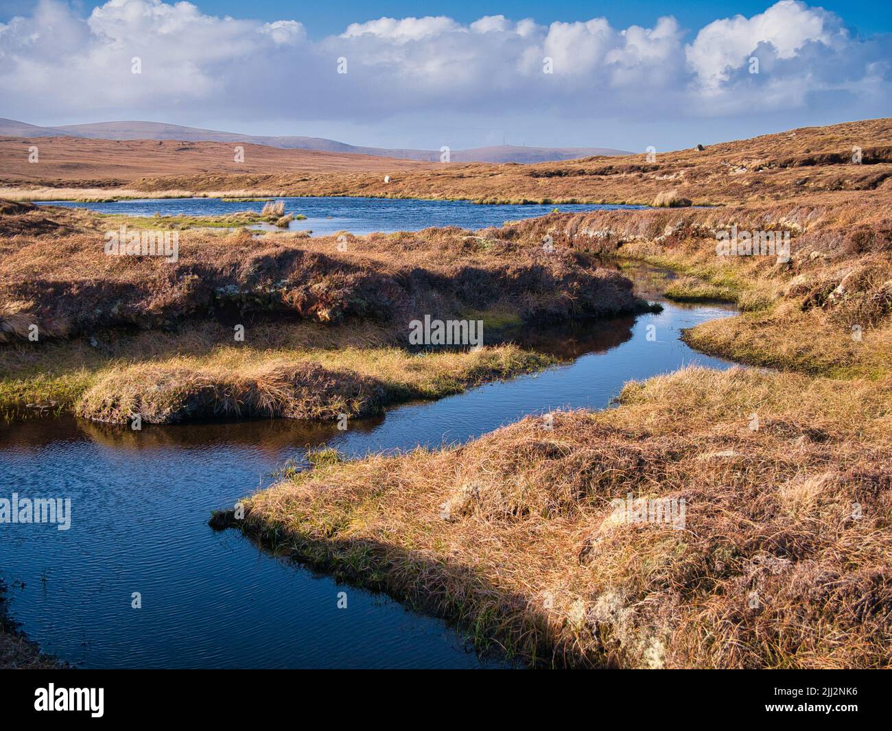 Un área pantanosa que forma turba cerca de Eshaness, Northmavine en Mainland, Shetland, Reino Unido. Tomada en un día soleado con cielo azul y nubes blancas. Foto de stock