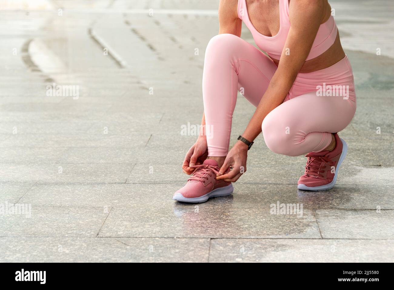 Mujer atando sus zapatos antes de correr o hacer ejercicio Foto de stock