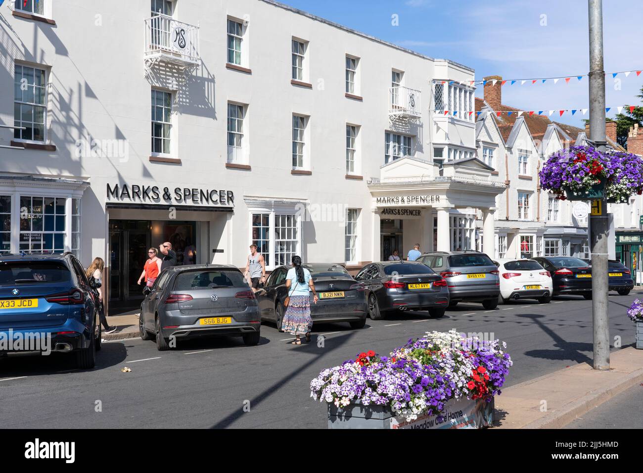 Los compradores entran y salen de Marks and Spencer en Bridge Street en el verano, julio, en Stratford upon Avon, Inglaterra. Concepto: Grandes almacenes, cadenas Foto de stock