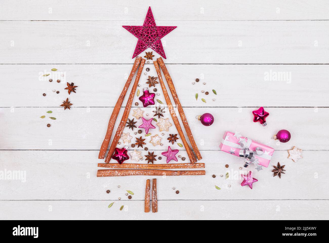 Toma de estudio con forma de árbol de Navidad hecha de varias especias, galletas y adornos de Navidad Foto de stock