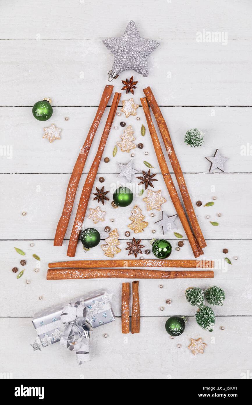 Toma de estudio con forma de árbol de Navidad hecha de varias especias, galletas y adornos de Navidad Foto de stock