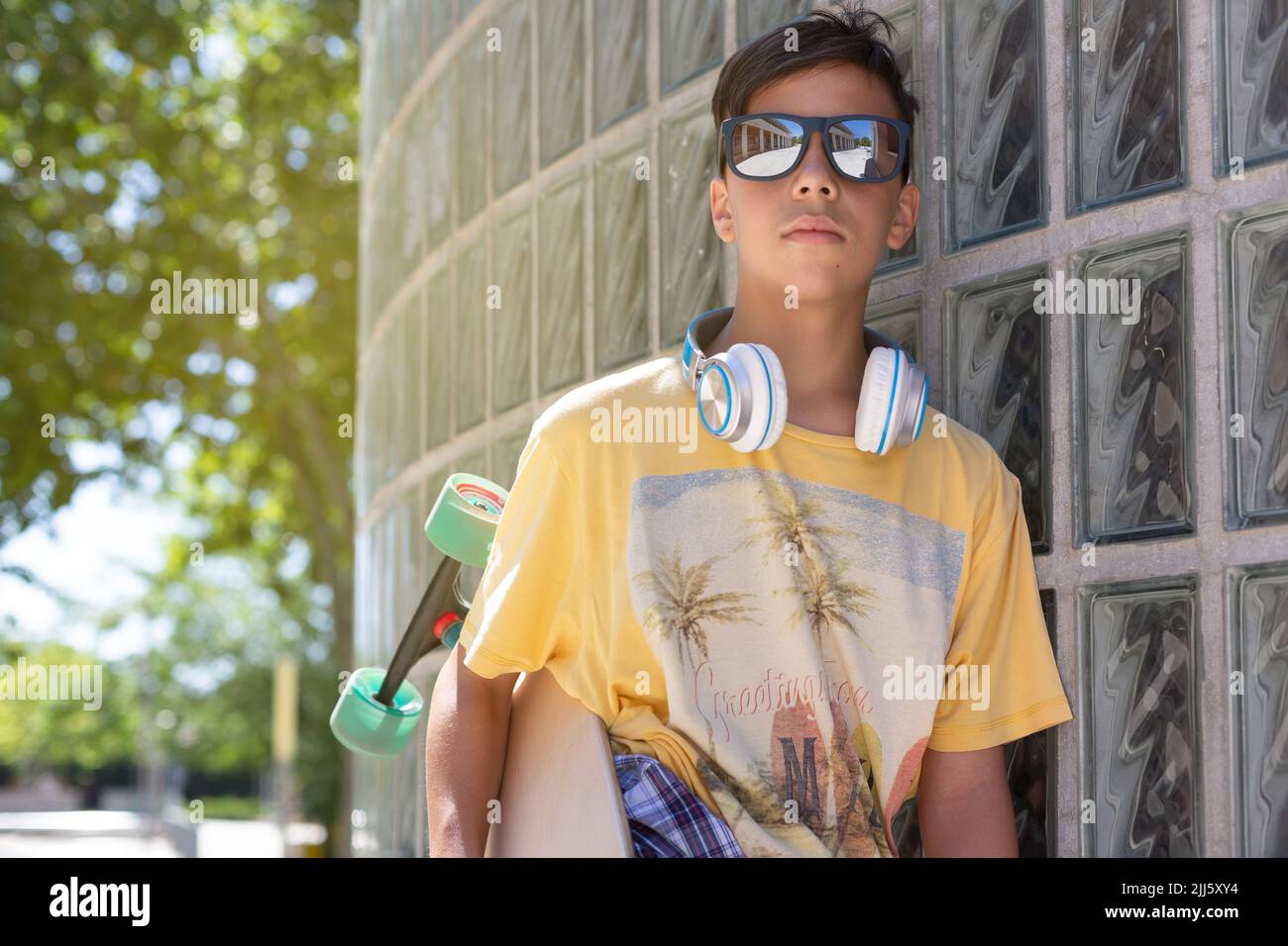 Retrato de adolescente caucásico skater chico con gafas de sol al aire libre. Concepto Freestyle. Espacio para texto. Foto de stock