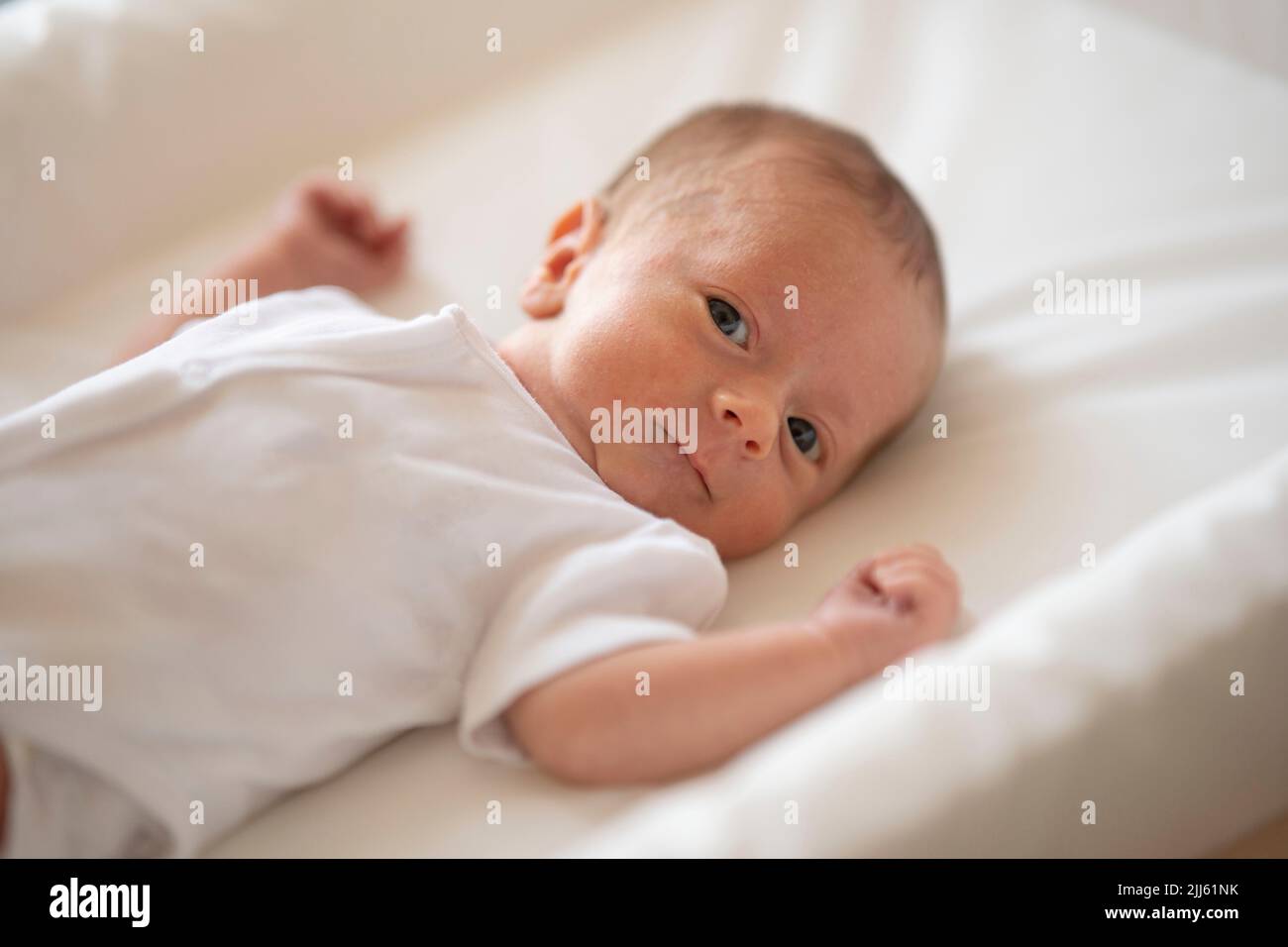 Lindo bebé mirando a la cámara Foto de stock
