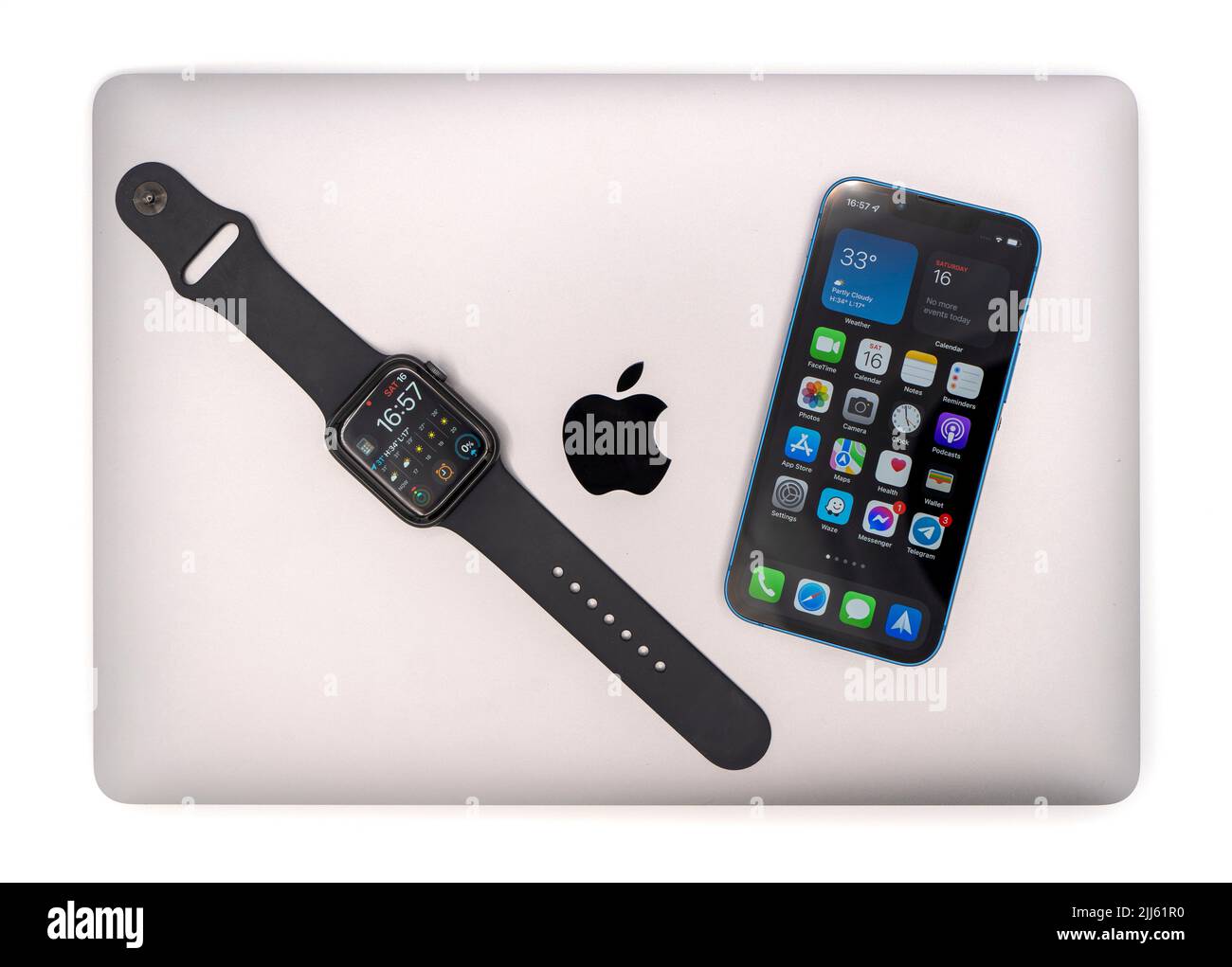 Productos Apple: Ordenador portátil MacBook Air, reloj inteligente Apple Watch y Apple iPhone 13 Mini Foto de stock