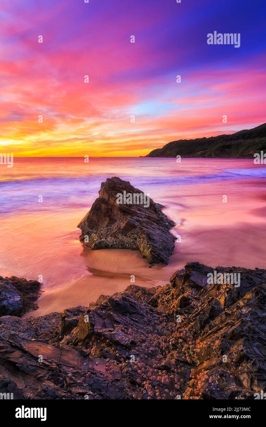 Escénico paisaje marino de colufrul al amanecer en la playa Burgess en la ciudad de Forster en Australia hacia el cabo Hawke headland. Foto de stock
