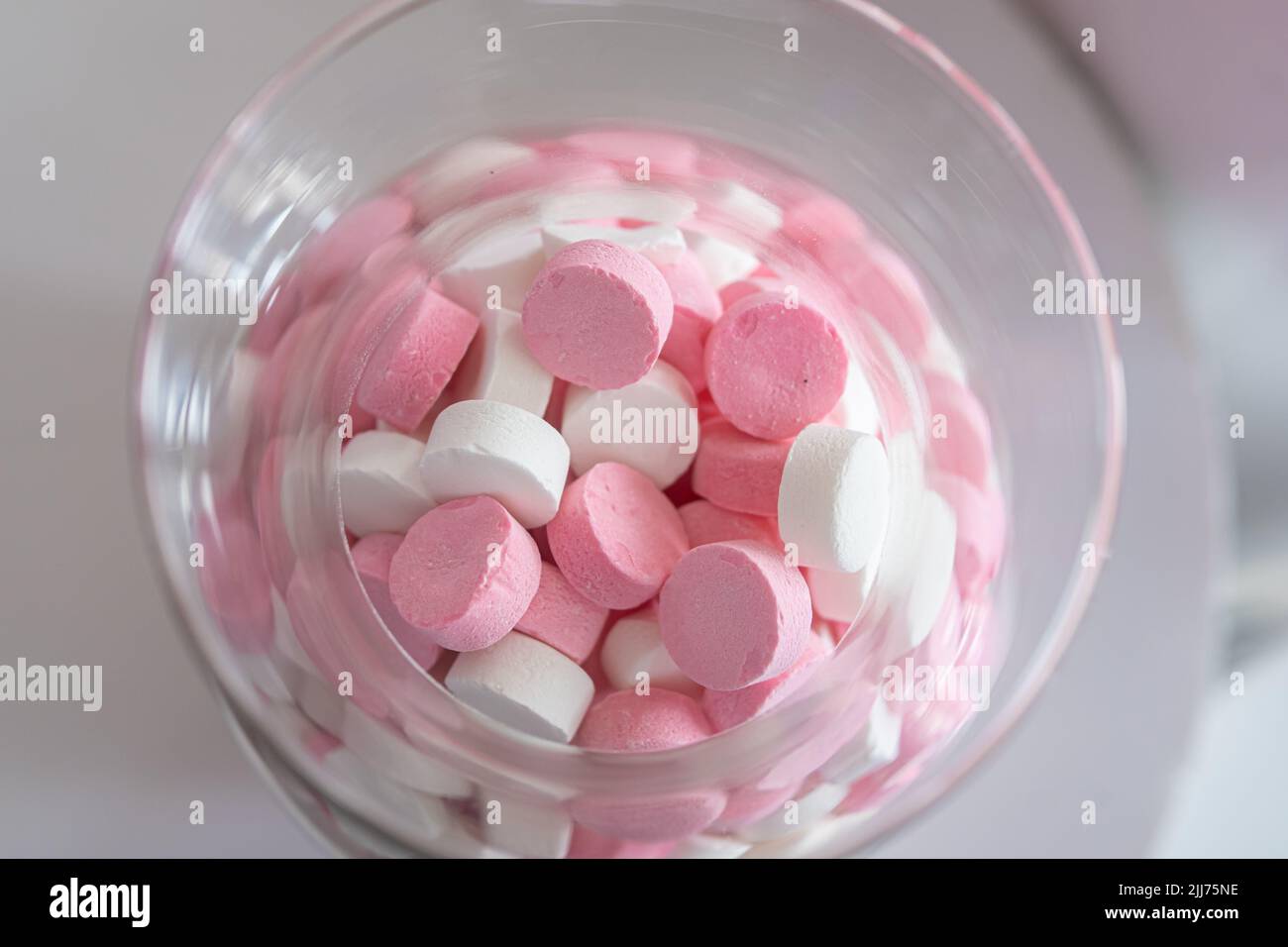 Dulces rosados y blancos en un tarro Foto de stock