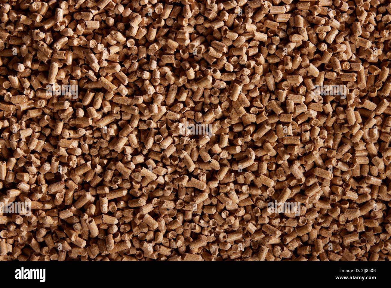 Vista superior de fondo natural de montón de pellets de madera cilíndricos esparcidos en la superficie durante el día Foto de stock