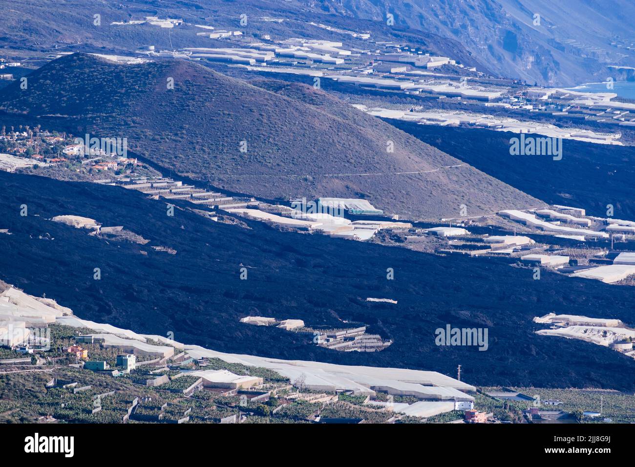 Montaña de Todeque rodeada de un flujo de lava solidificada. Destrucción causada por el río de lava en el valle de Aridane. La Palma, Islas Canarias, España Foto de stock